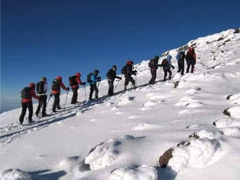 A line of climbers ascending the snow on a Kilimanjaro summit push