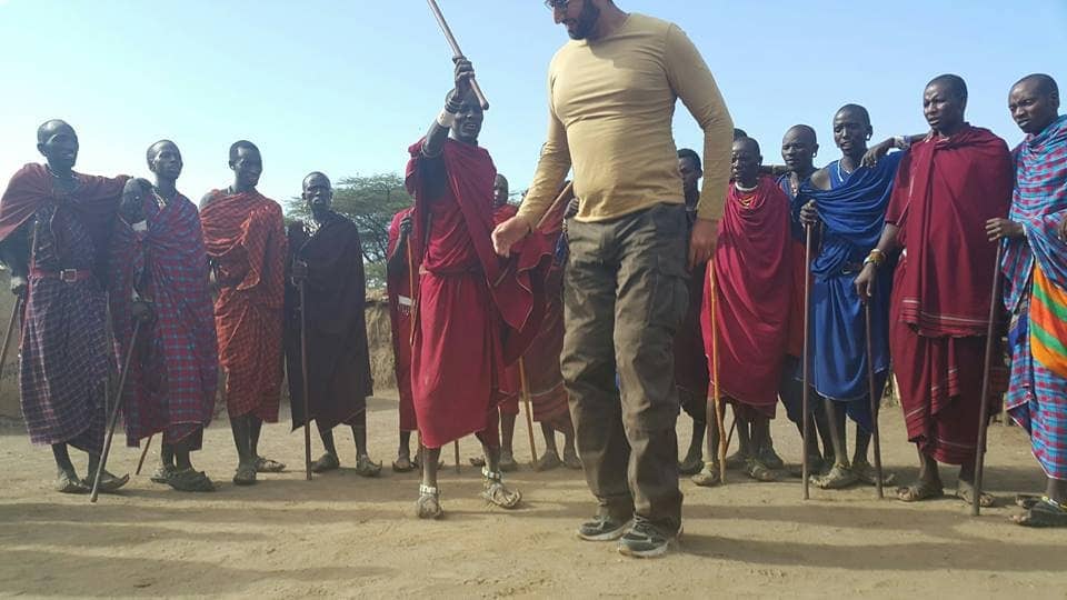 A guest dancing with Maasai warriors during a village visit